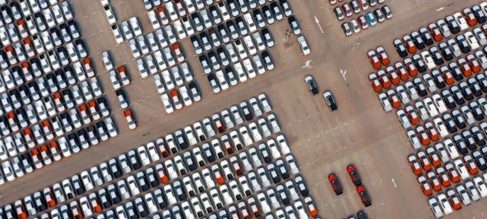 Visão aérea de carros no pátio de uma montadora