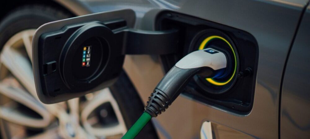Plug elétrico no carro, com a corda verde e receptor amarelo